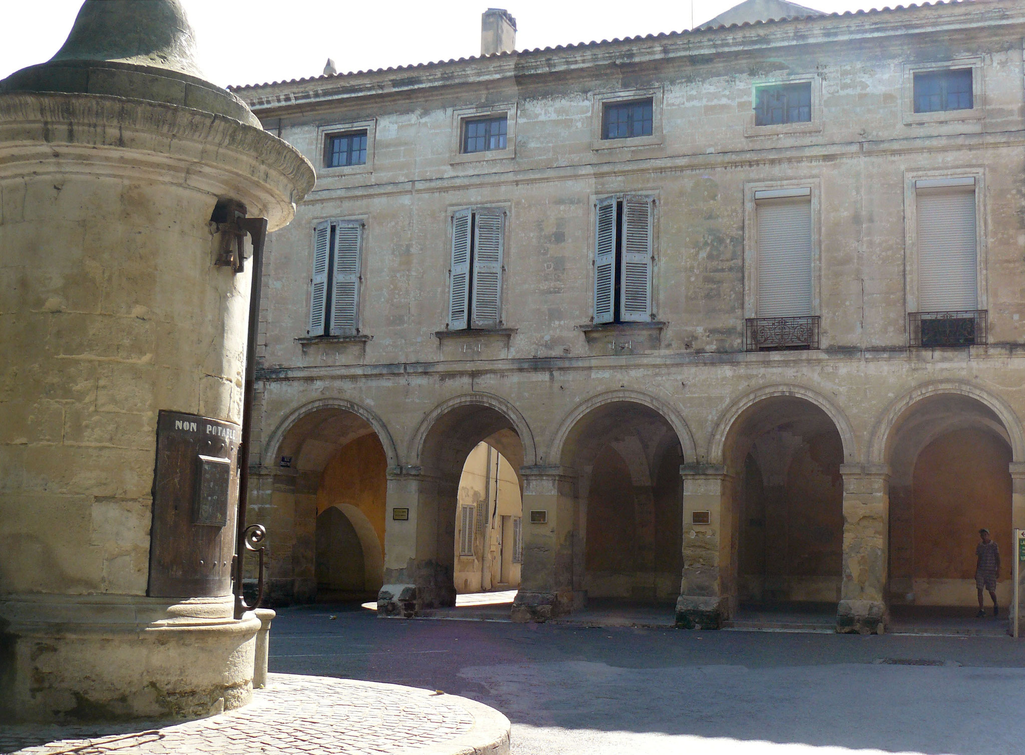 Les arcades de la place de la Mairie et la fontaine