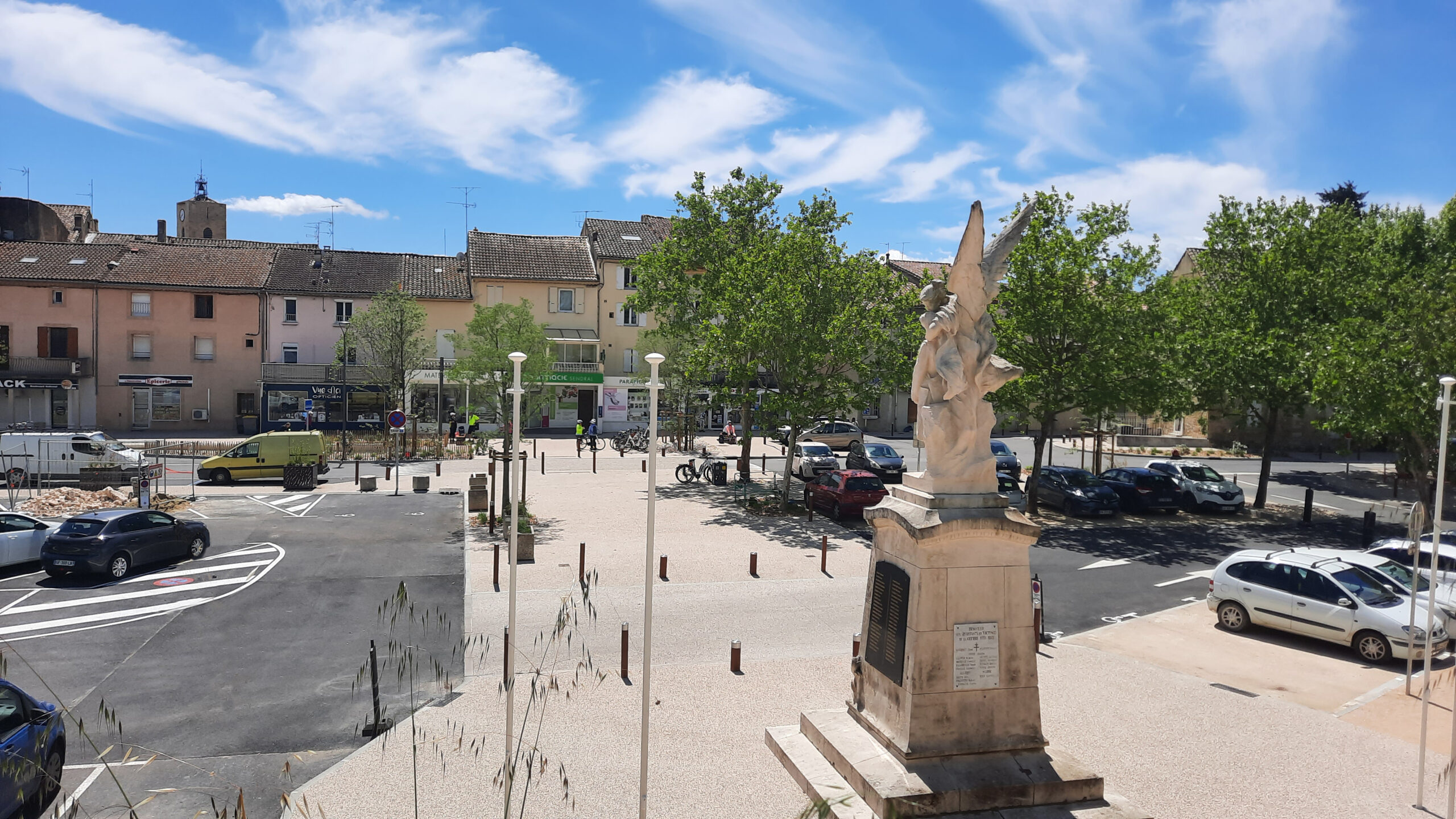 L’esplanade de la Pousterle réaménagée, le monument aux morts au premier plan et le parking