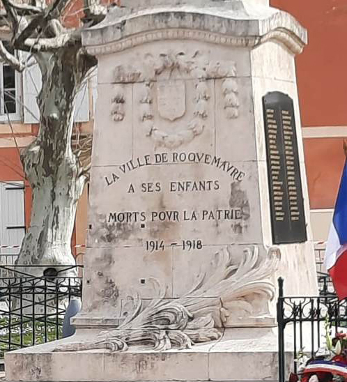 Face principale du socle du monument aux morts : armoiries de la ville dans une guirlande, inscription « La ville de Roquemaure à ses enfants morts pour la patrie 1914 1918 », palme sculptée et plaque des noms à droite