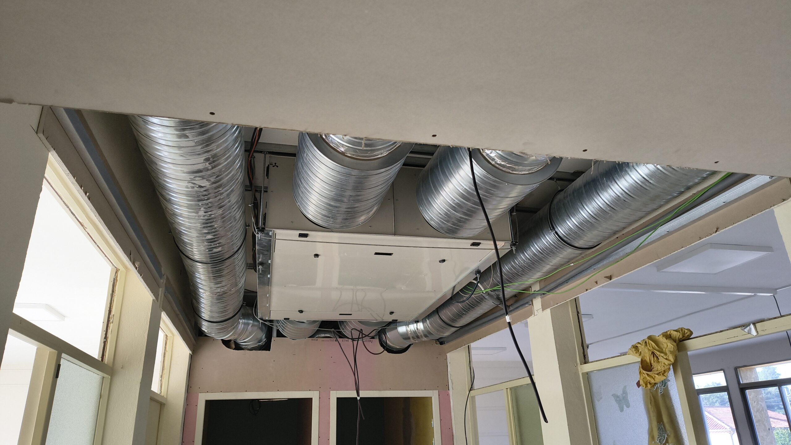 Gaines de la ventilation double flux installées au plafond d’une classe en travaux