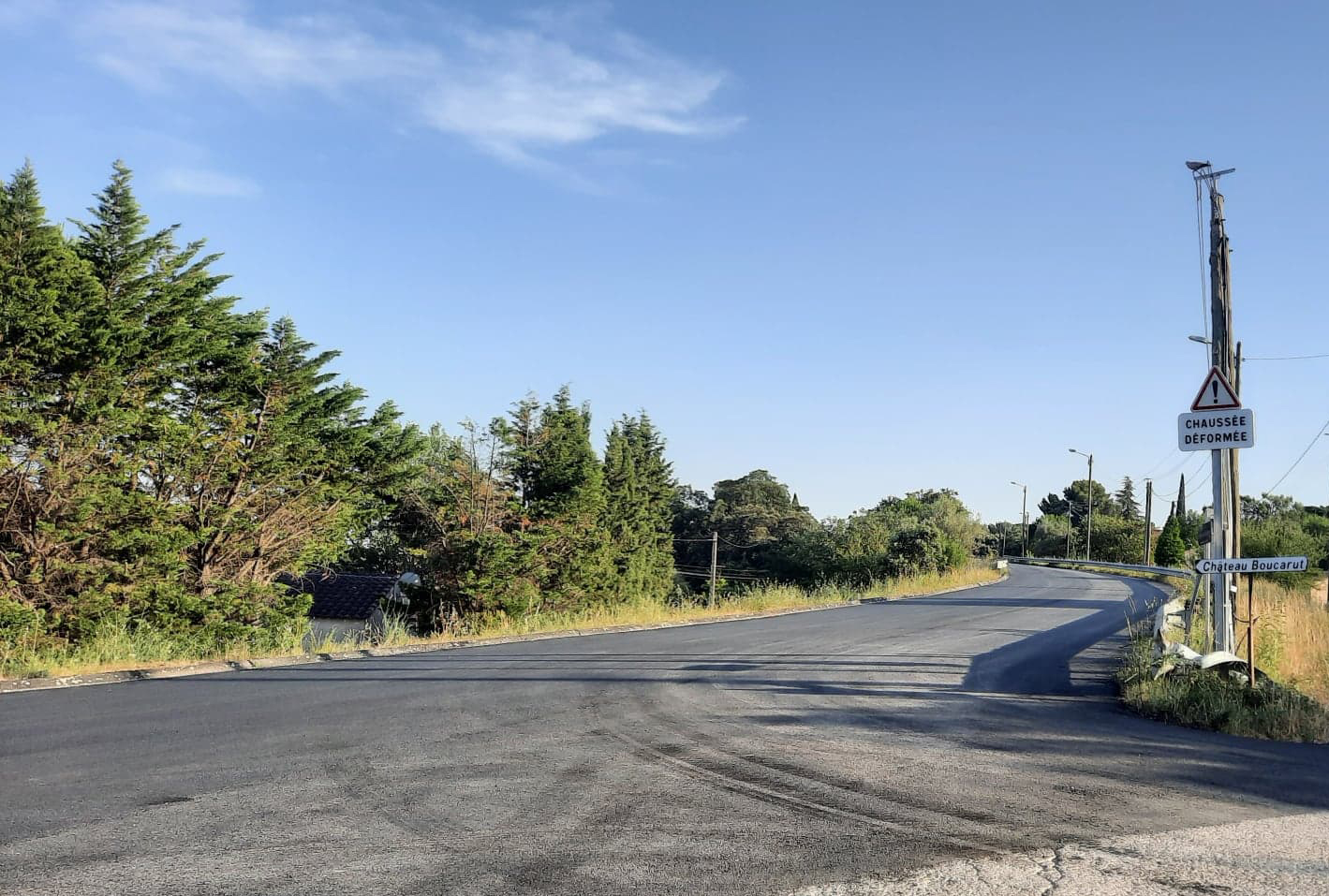 La route de la montée de la Plaine refaite, bordée de pins et de haies