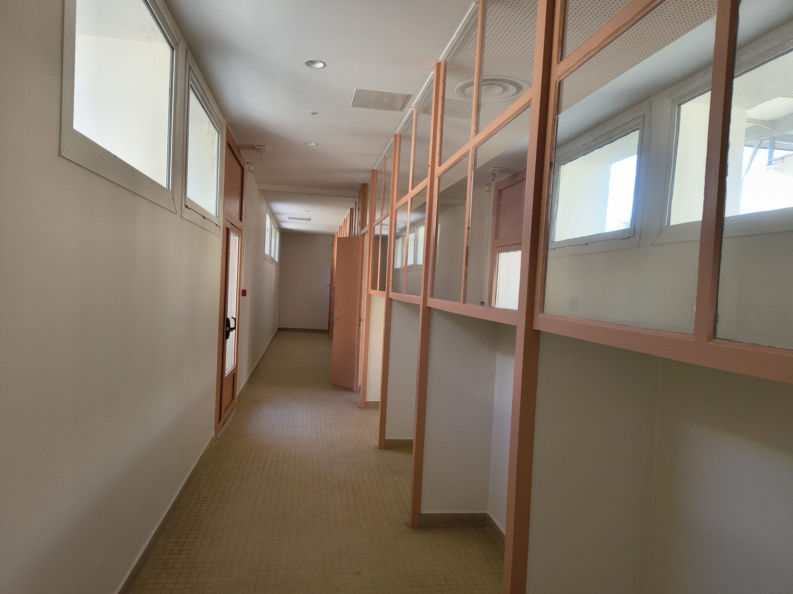 Couloir rénové du bâtiment Gérard-Philipe, bordé de cloisons vitrées