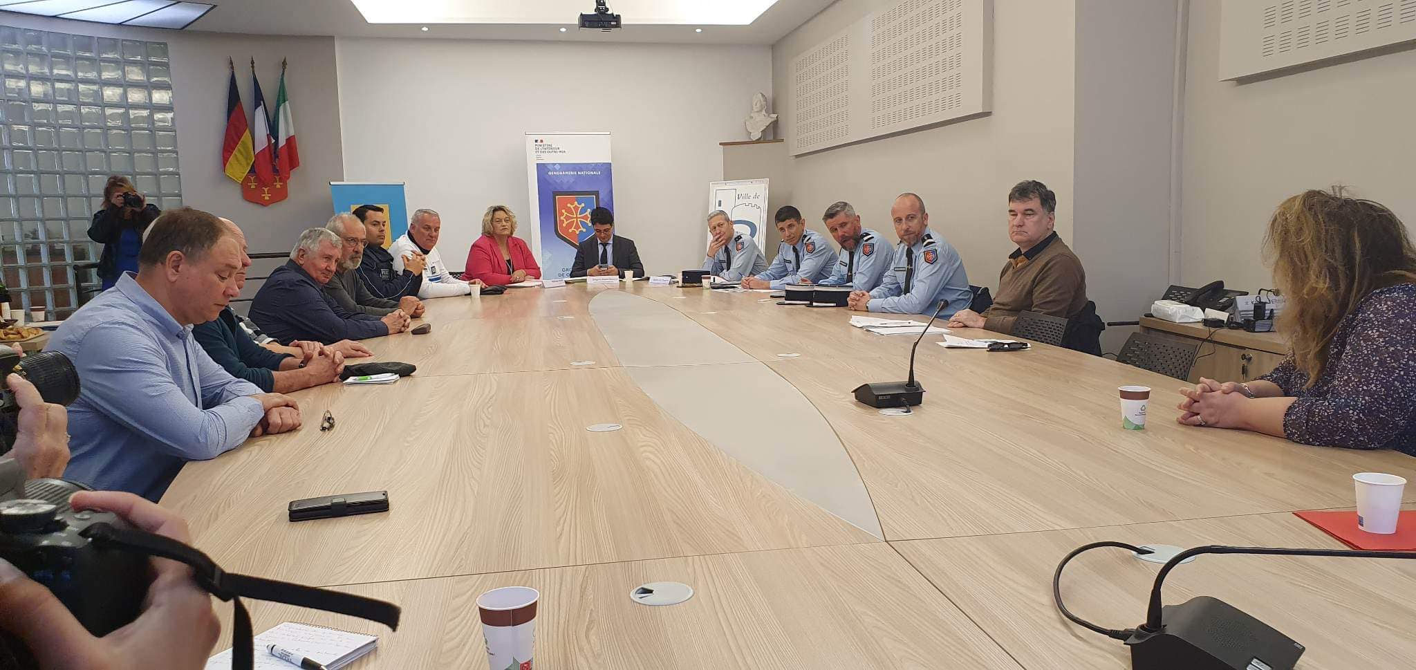 Réunion autour d’une grande table en mairie : représentants de la préfecture, de la gendarmerie et de la commune lors de la signature du protocole