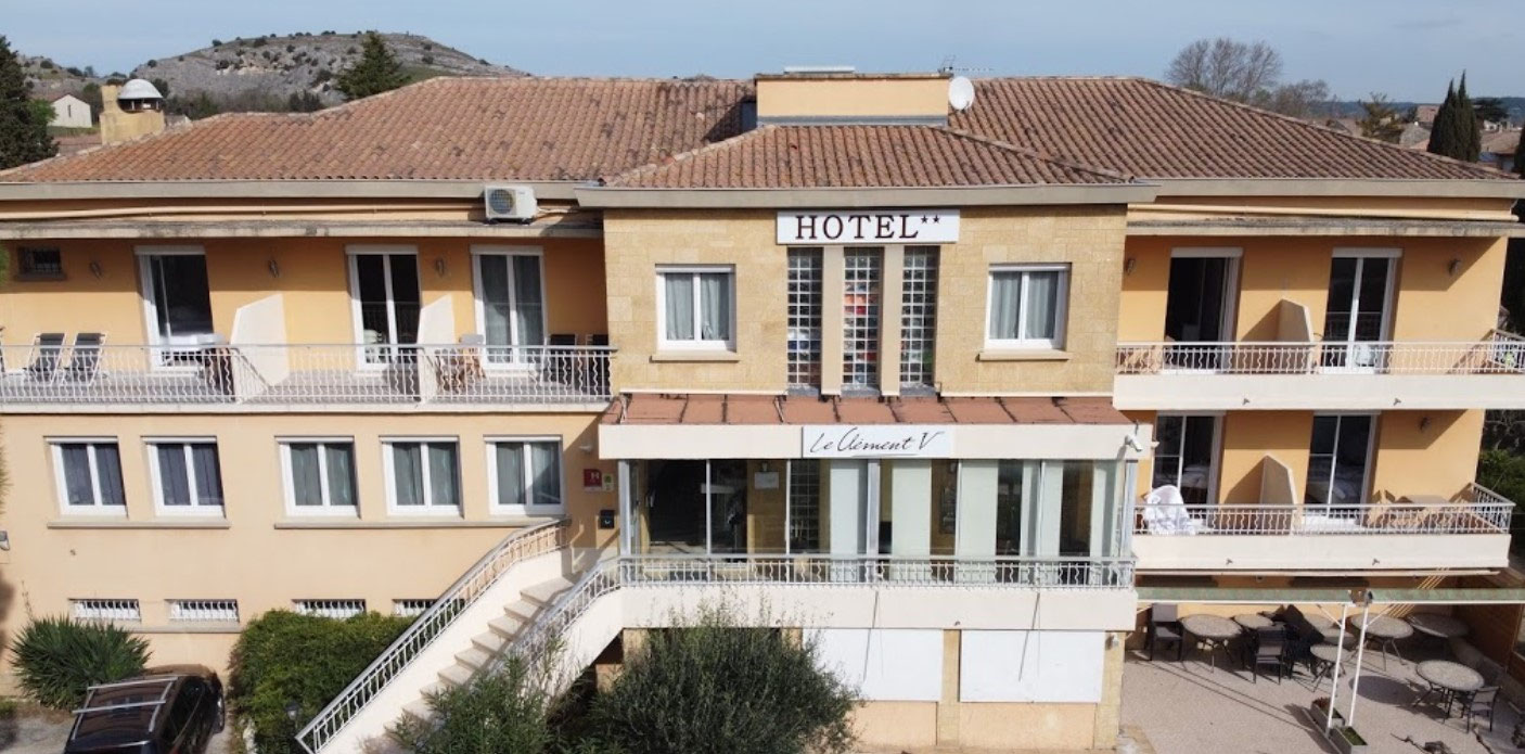 Façade de l’hôtel Le Clément V avec ses balcons et l’enseigne Hôtel