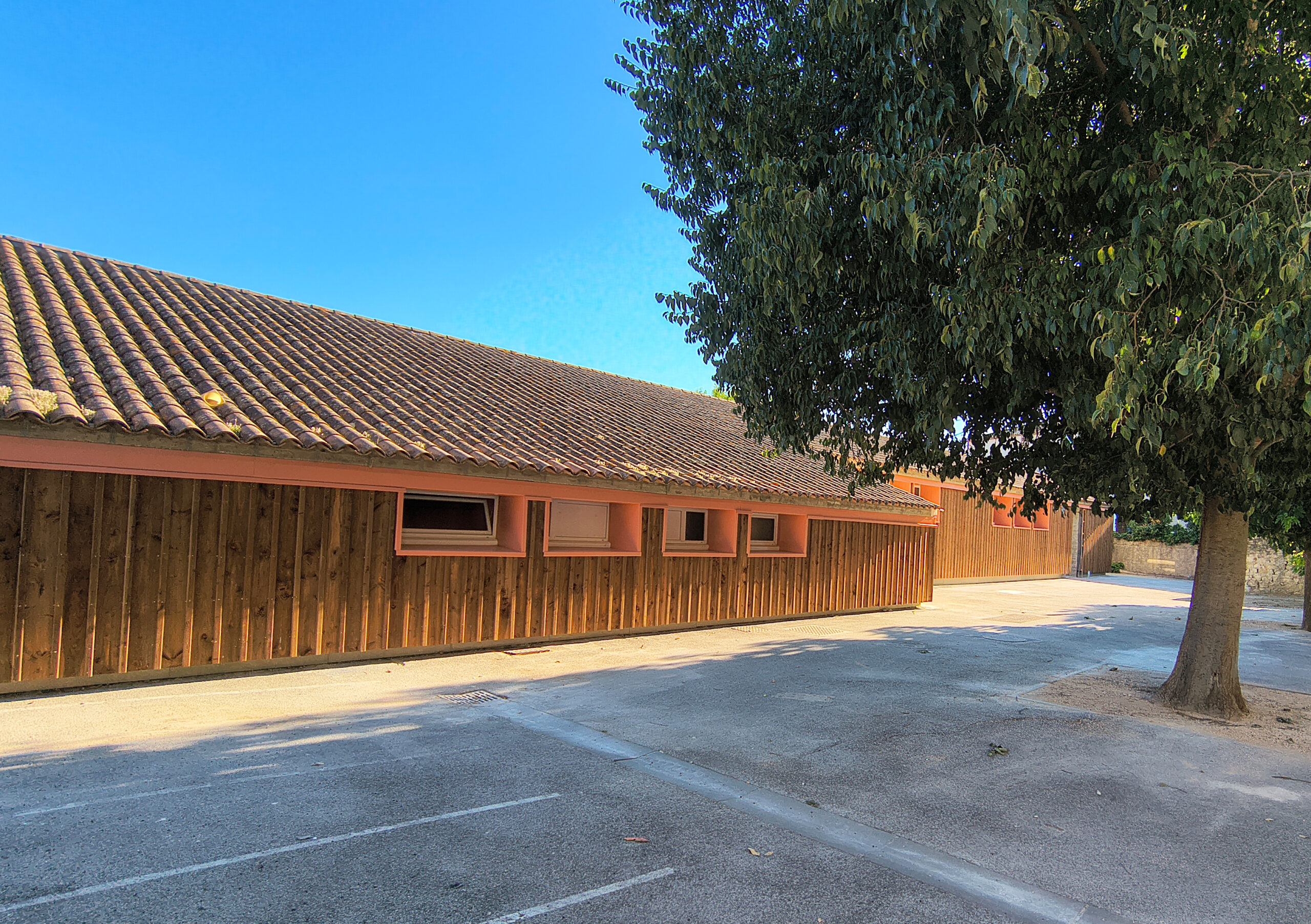 Le bâtiment Gérard-Philipe rénové, avec son bardage en bois et ses menuiseries neuves, au bord de la cour