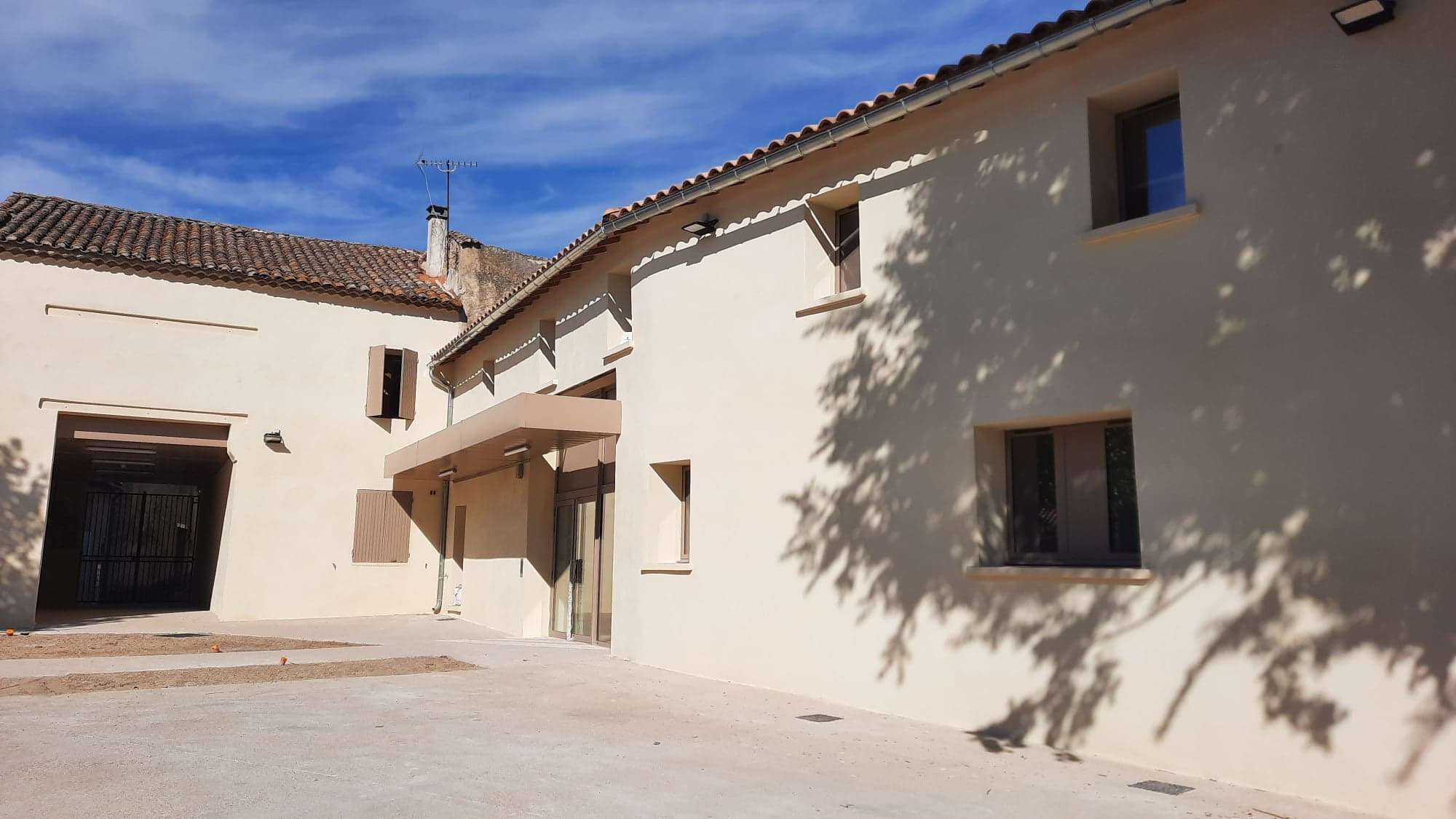 La maison de santé vue de côté, façades enduites et auvent d’entrée