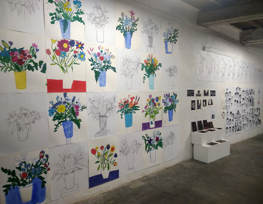 Mur de l’atelier couvert de bouquets de fleurs peints et dessinés par les élèves