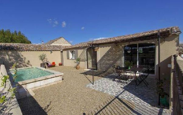 Maison de pierre de plain-pied avec une petite piscine et une cour de gravier