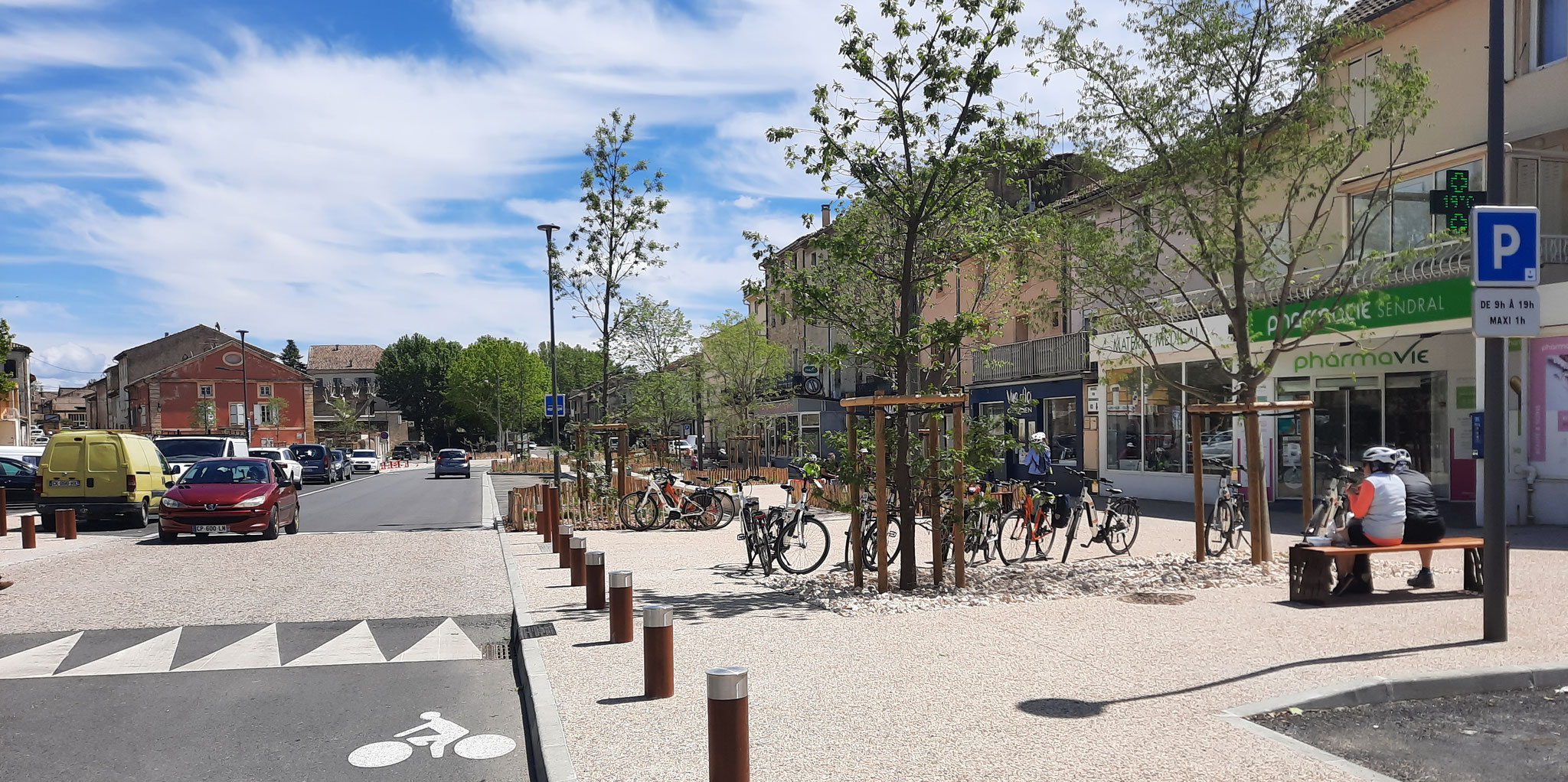 L’esplanade devant les commerces du boulevard National : bancs, vélos stationnés et jeunes arbres